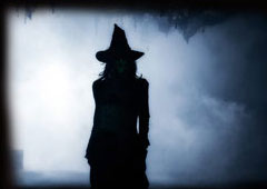 silhouette of a witch with a foggy, nightime background